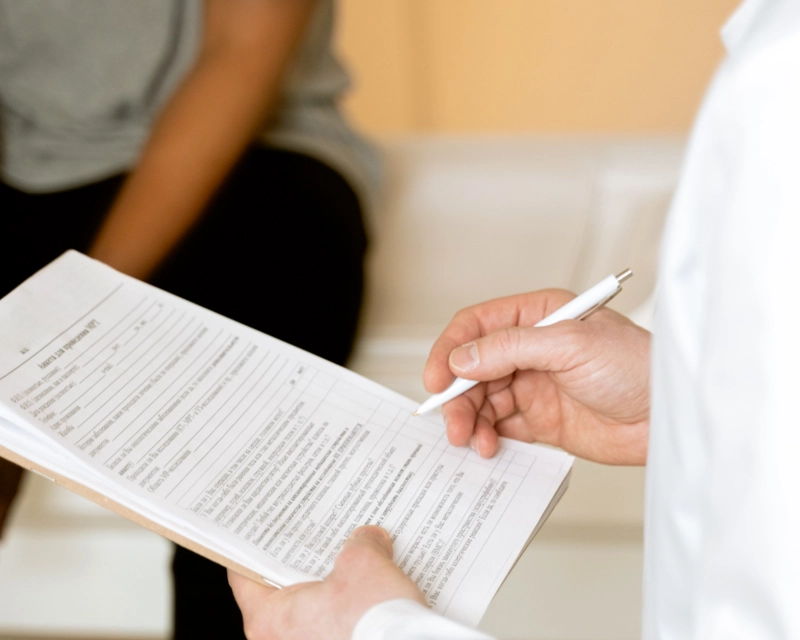 Doctor consulting and reviewing health forms..